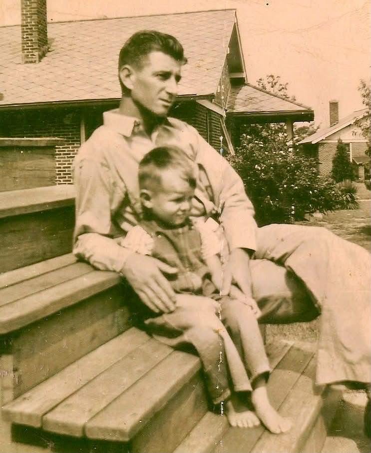 Charles Alfred Westbrook seated outdoors with his young son Robert C. 'Bobby' Westbrook around 1943.