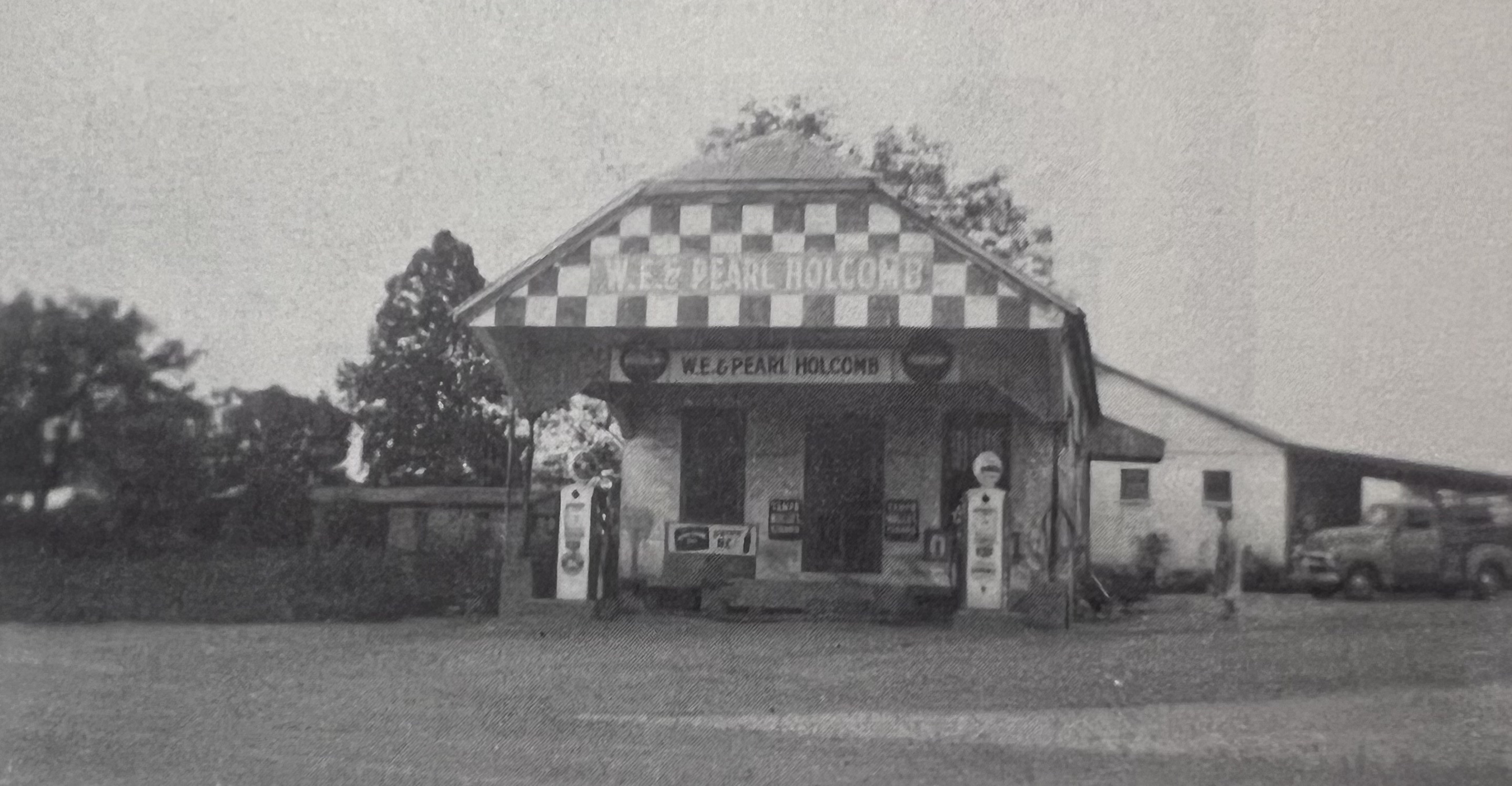 Black-and-white photograph of the W. E. & Pearl Holcomb Store at Coal Mountain, with gas pumps in front.