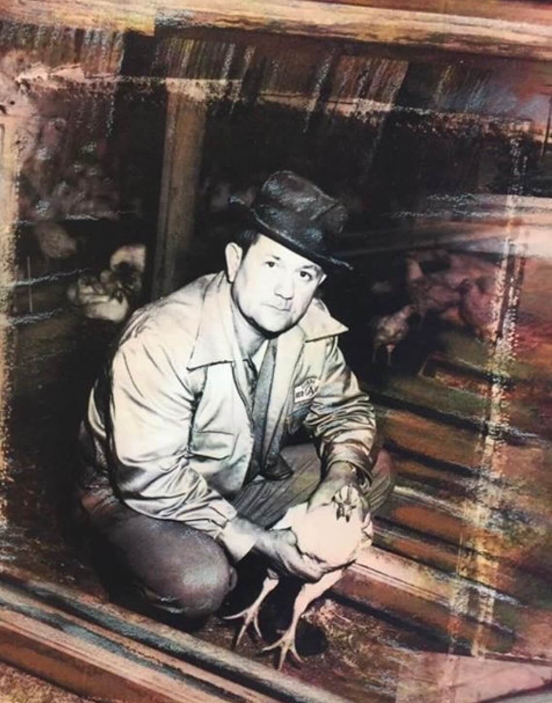 Eldo Grogan holding a chicken inside a poultry house.