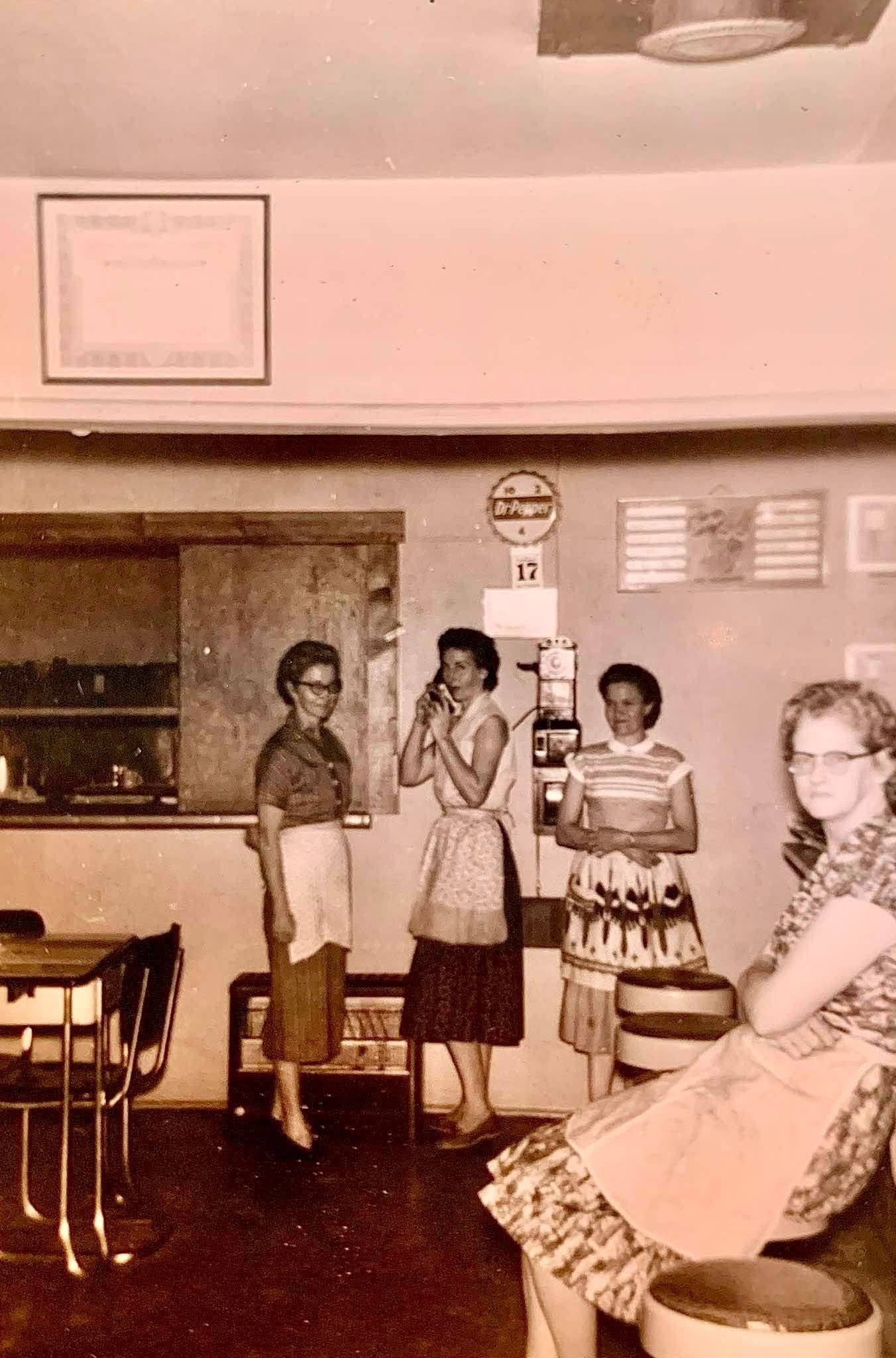 Katie Milford Shoemake standing at far left with other women inside the S&M Cafe around 1960.